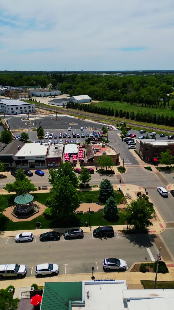 Et fugleperspektiv viser det charmerende centrum af Huntley, Illinois, under en lys sommerhimmel