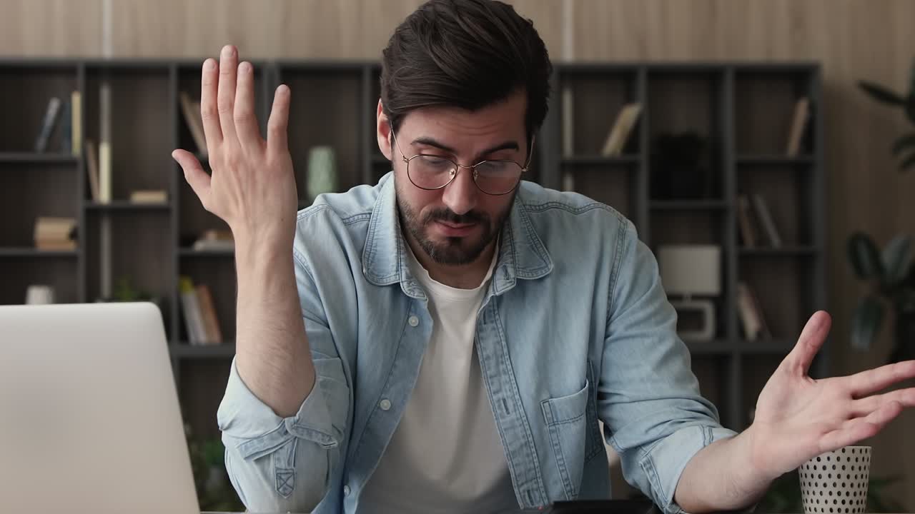 Unhappy young man feeling stressed calculating expenses.