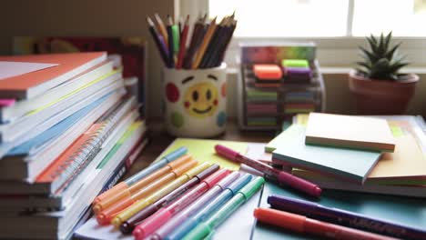 a vibrant workspace filled with colorful stationery, notebooks, markers, and sticky notes showcasing a creative environment for productivity and organization