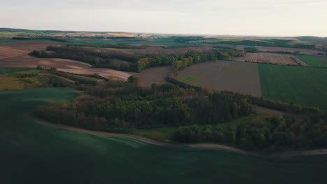 beautiful diverse landscape shot at sunset. golden hour shining through forests and meadows. a game of shadows and lights. drone shot from a bird's eye view. south moravia, czechia
