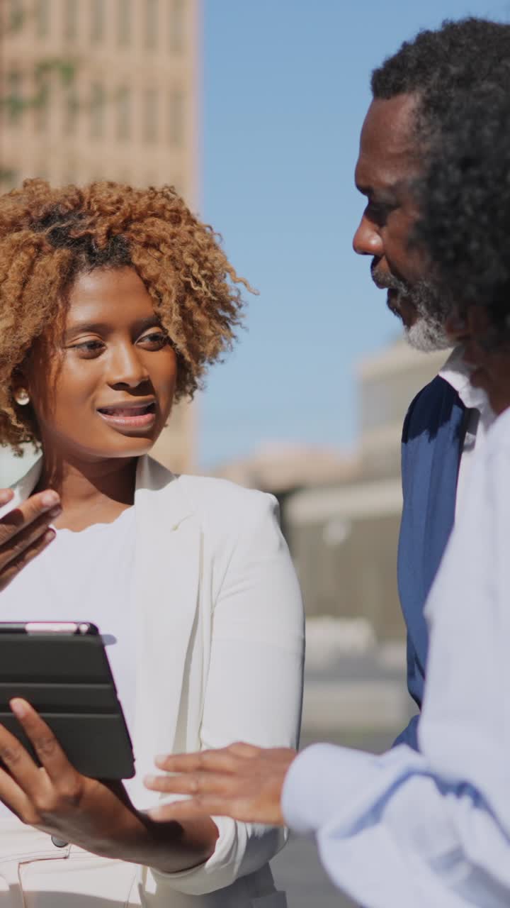 Imprenditrice africana che utilizza un tablet durante una riunione all'aperto