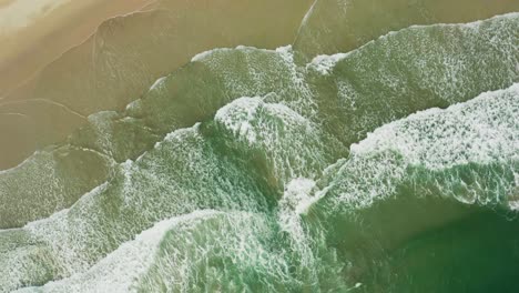 Vista-Giratoria-Aérea-De-La-Impresionante-Playa-De-Arena-Con-Olas-Tropicales-Rodando-Hacia-La-Orilla