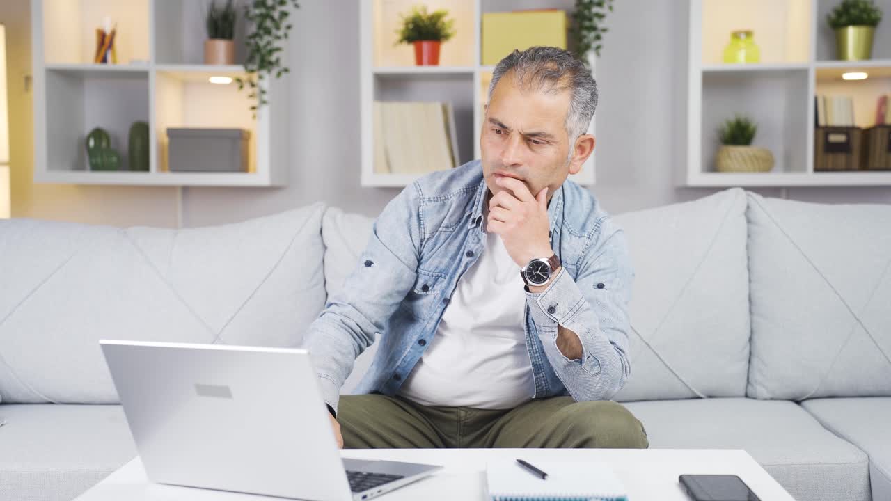 Satisfied with what he sees on the laptop, the man nods.