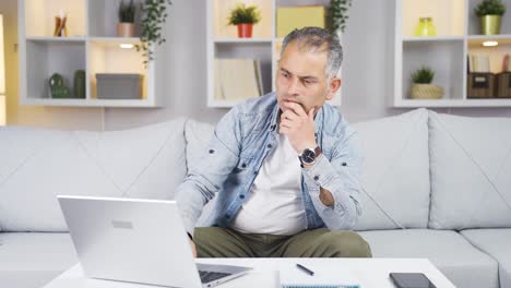 Zufrieden-Mit-Dem,-Was-Er-Auf-Dem-Laptop-Sieht,-Nickt-Der-Mann.