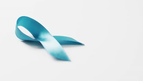 Video-of-blue-ovarian-cancer-awareness-ribbon-on-white-background-with-copy-space