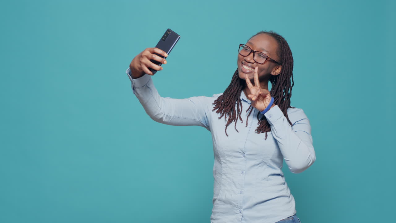 Cheerful happy woman taking pictures on smartphone app