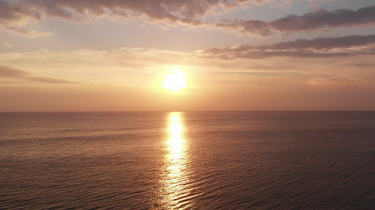 View from a Drone Flying up at Sunrise over the Sea