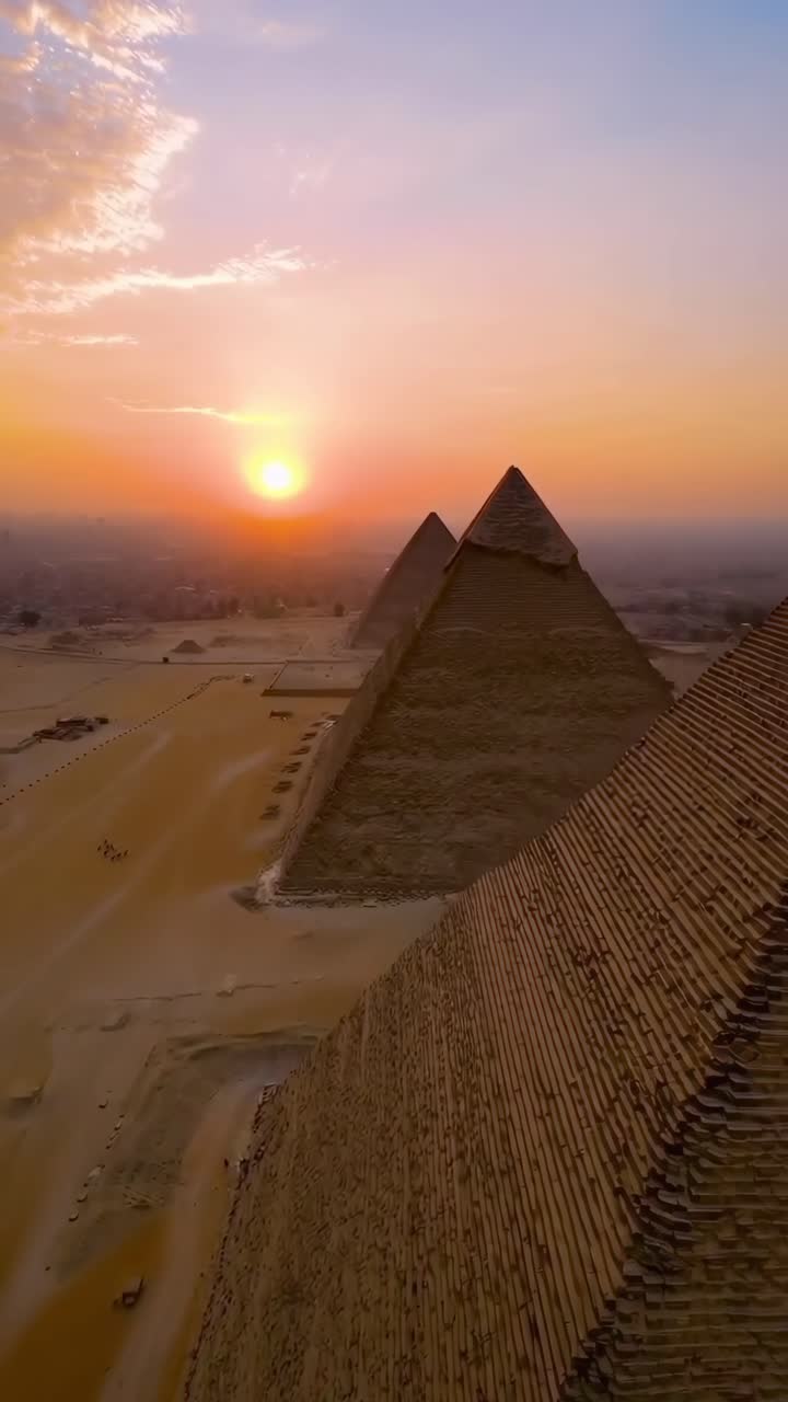 Video aereo cattura le piramidi al tramonto, mettendo in mostra la loro grandezza da un'angolazione elevata.