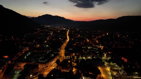 puesta de sol sobre la ciudad de montaña con timelaps de tráfico