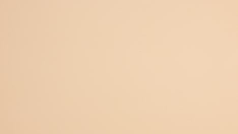 las botellas de esmalte de uñas caen sobre un fondo beige.