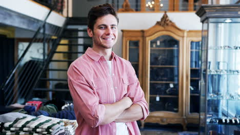 Portrait-Of-Male-Owner-Of-Fashion-Store-Pulled-Into-Focus-In-Front-Of-Clothing-Display