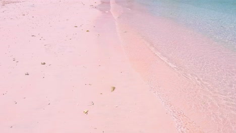 Popular tourism destination of Pink Beach with ocean waves lapping onto sand in East Nusa Tenggara, Indonesia