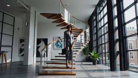 businesswoman walking up modern spiral staircase