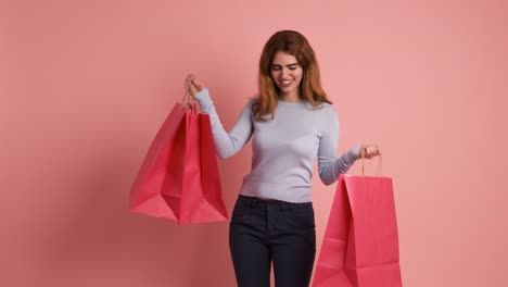 happy young woman with many pink shopping bags