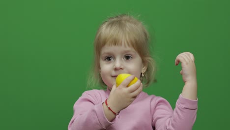 beautiful young girl eats a lemon with a grimace on her face. chroma key