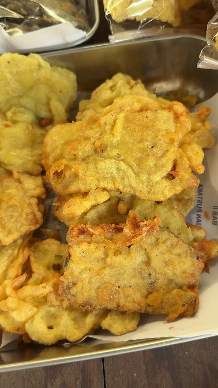 Primo piano di snack fritti dorati e croccanti in esposizione.