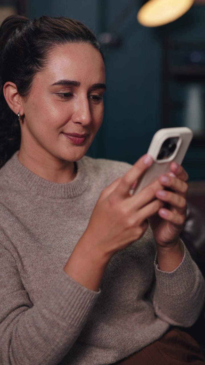 Giovane donna che usa lo smartphone in un ambiente interno accogliente