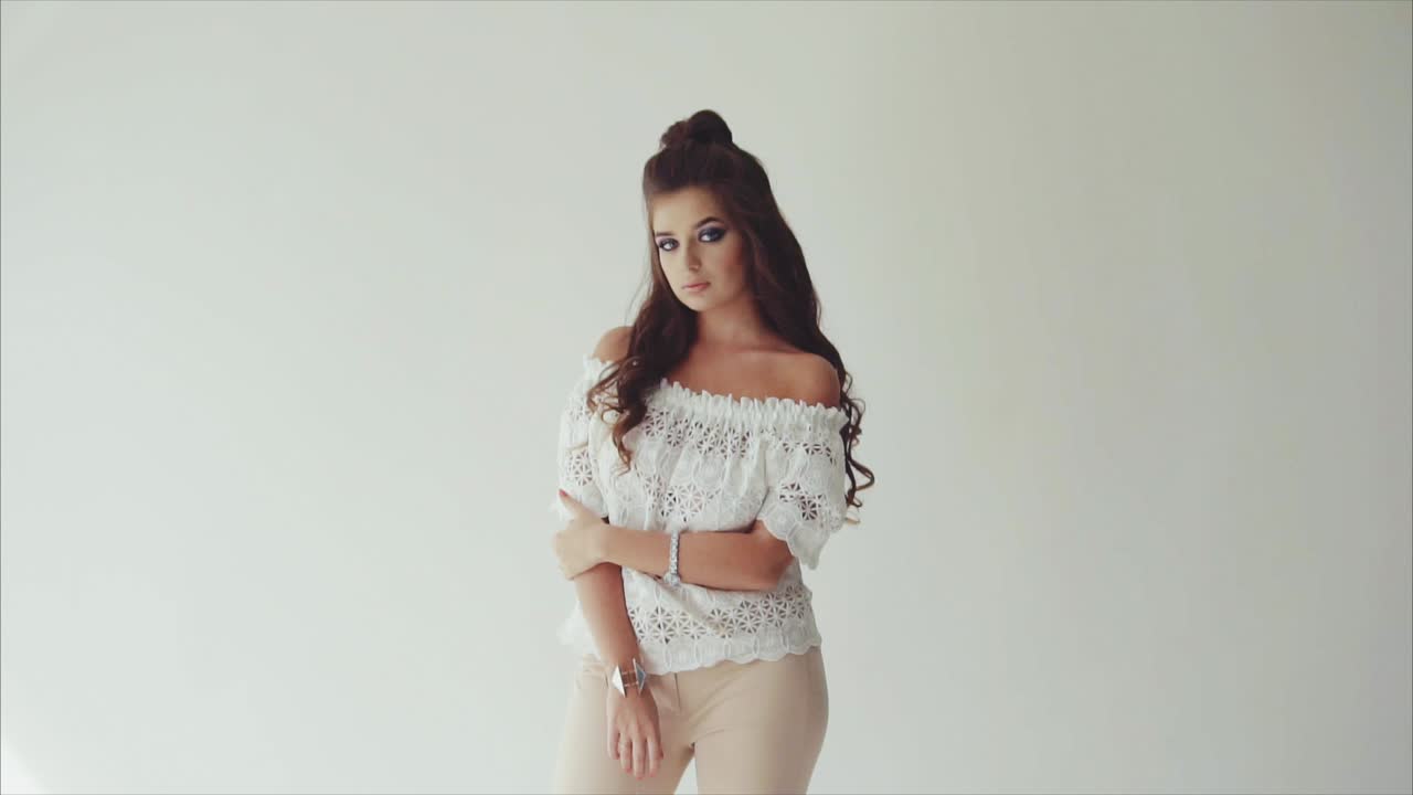 mujer de moda con camiseta blanca y pantalones beige