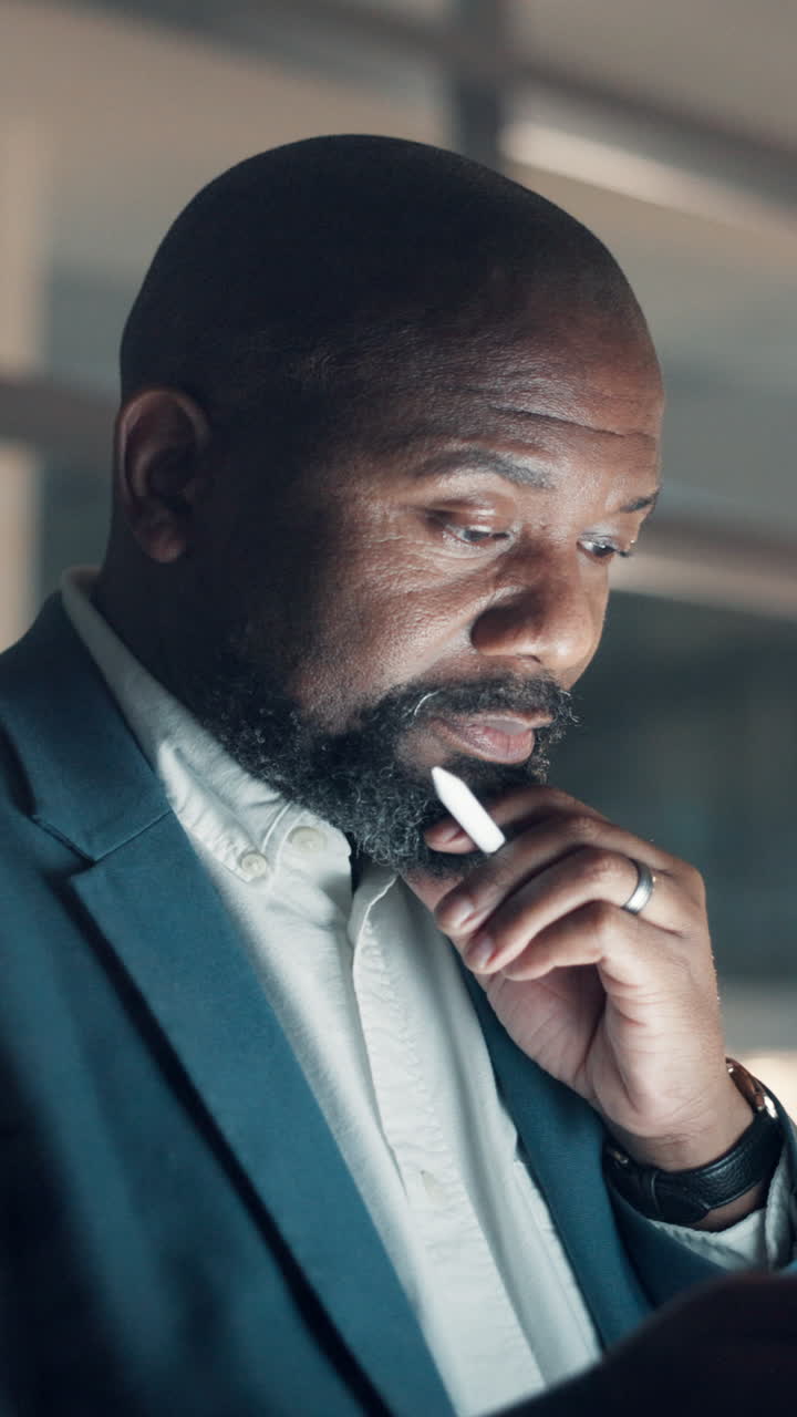 Uomo di colore professionista che guarda lo schermo con lo stilo