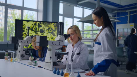 científicos observando muestras bajo microscopios en un laboratorio