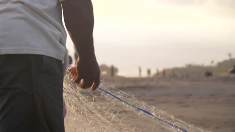 fisherman gathering up a fishing net