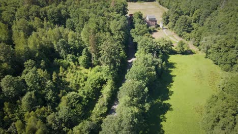 Luftüberführung-über-Ein-Ländliches-Deutsches-Herrenhaus-Und-Eine-Straße,-Die-Zwischen-Einer-Reihe-Von-Bäumen-Verläuft