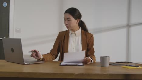 businesswoman in office reviewing and making notes on application or cv for job vacancy 4