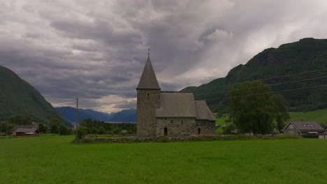 Histórica-Iglesia-De-Piedra-De-Hove-En-El-Campo-Bajo-Un-Cielo-Siniestro,-Vik