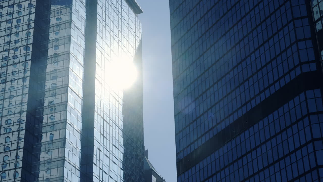 Arquitetura empresarial moderna com paredes de vidro e aço refletindo os raios solares.