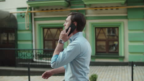 serious business man talking phone outdoors. businessman walking with smartphone