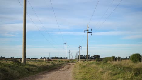 Camino-De-Tierra-Rural-Con-Postes-Eléctricos-De-Cemento