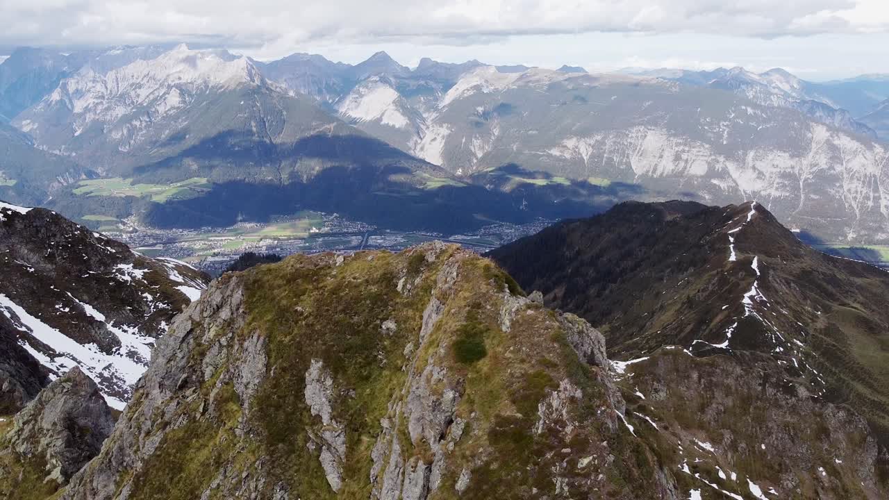 antena cinematográfica de la cima de la montaña de los alpes con una vieja capilla de madera en un pico empinado