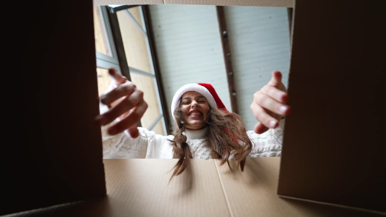 vrouw die een kerstcadeau opent.