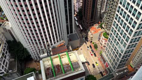 bird's eye view of traffic on small road in wan chai amongst hopewell center and skyscrapers in hong kong's concrete jungle