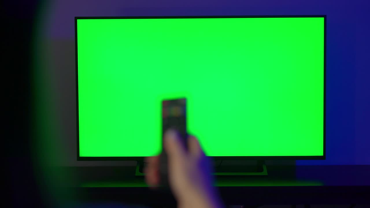 젊은 여성이 의자에 앉아 tv를 보고 있다.