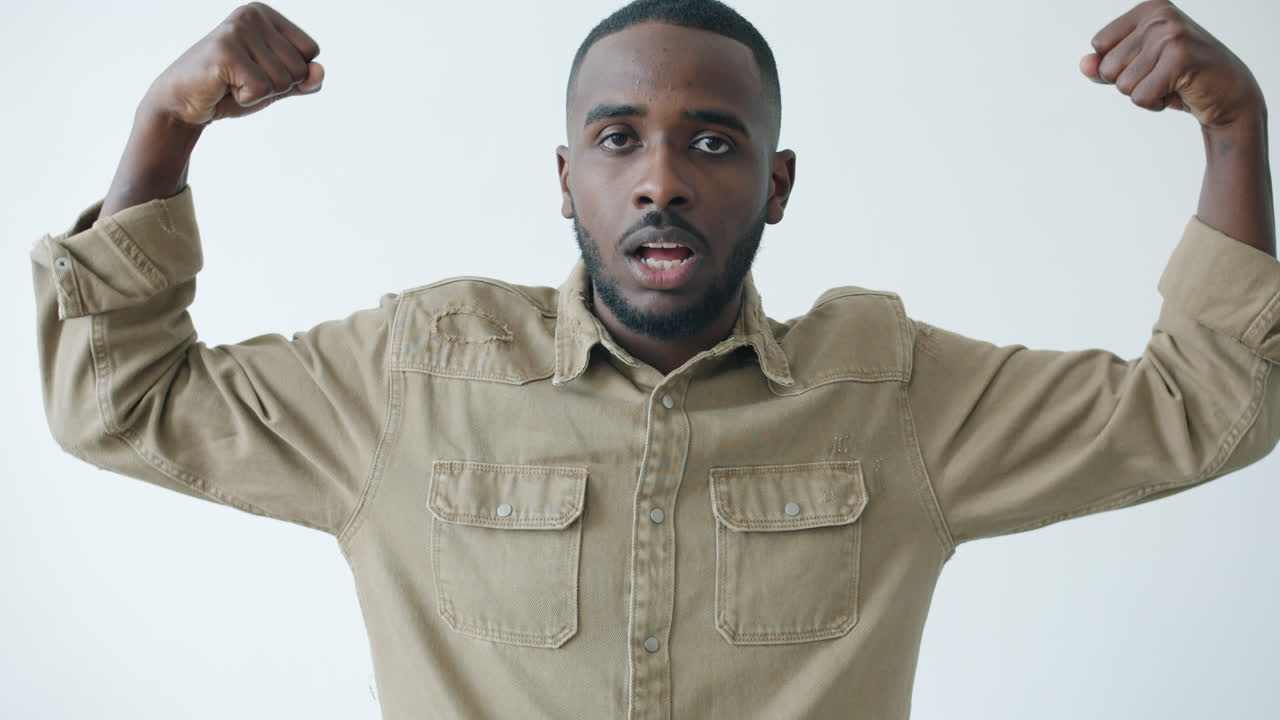 Man flexing muscles in a tan shirt