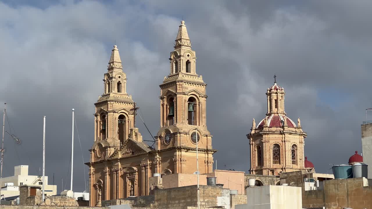 iglesia parroquial de nuestra señora del sagrado corazón, sliema, malta: una toma de 4k muestra la arquitectura neogótica contra nubes dramáticas