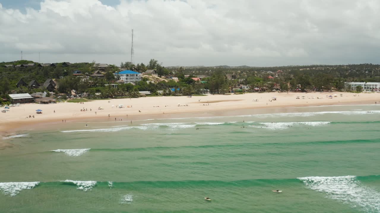 tiro de drones acercándose a la playa por encima de las olas en tofo, mozambique