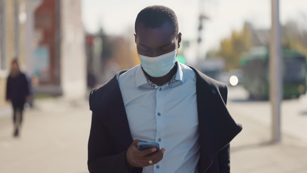 Man Walking and Using Smartphone in City During Pandemic