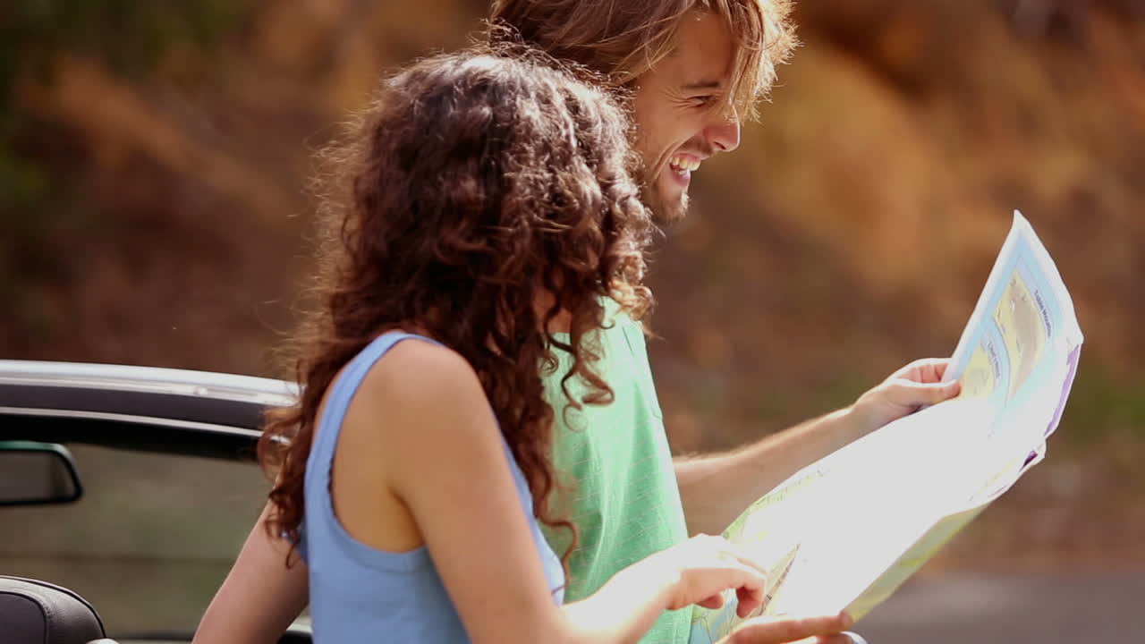 una pareja sonriente de pie junto a su coche
