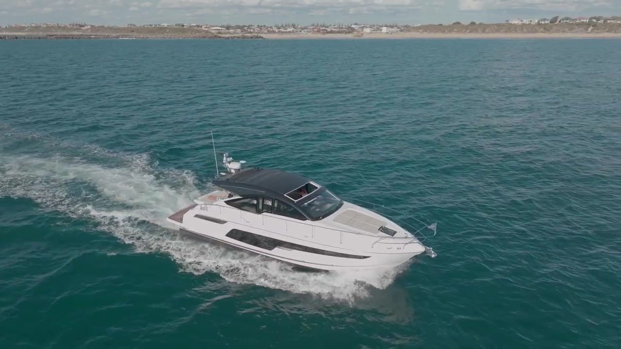 Ripresa aerea cinematografica di uno yacht che naviga nelle acque turchesi al largo di Mandurah, Australia, mostrando il vasto Oceano Indiano e la splendida costa dell'Australia Occidentale