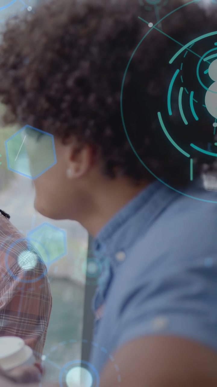 Vertical video: Man speaking, leaning and gesturing at peer, HUD shifting to show business data
