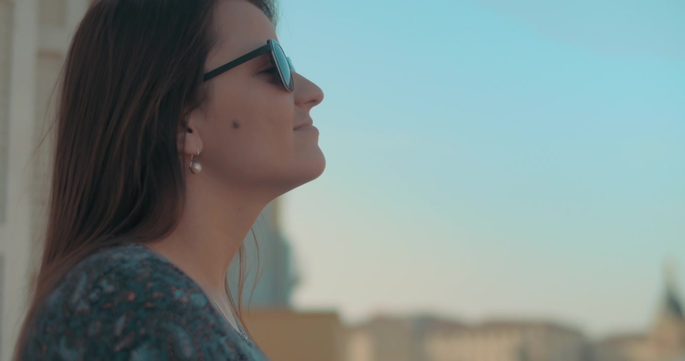 Giovane donna che si gode la vista del tramonto dal balcone