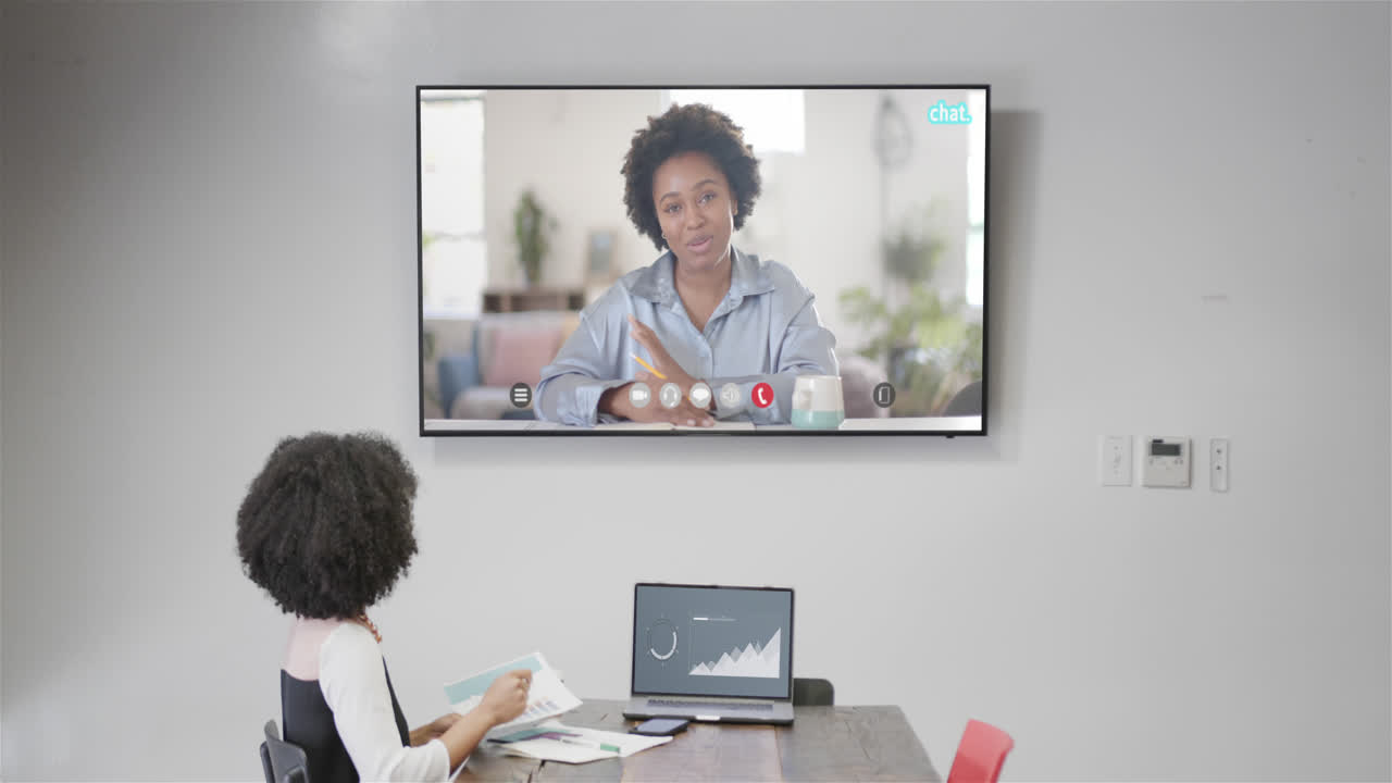African american businesswoman on video call with african american female colleague on screen