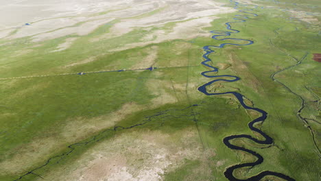 vista aérea de las colinas de alabama con el río owens serpenteando a través del paisaje, destacando el contraste entre las exuberantes orillas del río y el entorno árido bajo un cielo despejado.