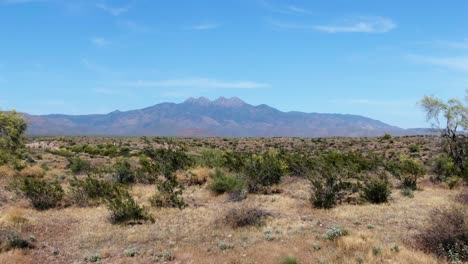 vista aérea baja sobre el desierto, hacia las cuatro cumbres de las montañas en el soleado arizona
