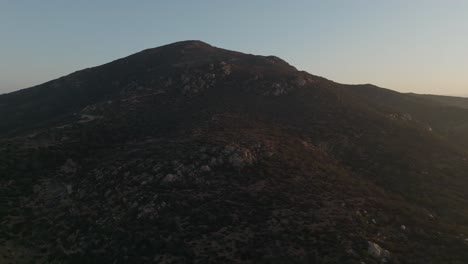 Aerial-view-of-Cowles-Mountain-in-suburb-San-Carlos-during-the-sunrise-in-San-Diego-Calforinia,-wide-orbit-shot-of-switchbacks-hiking-trail