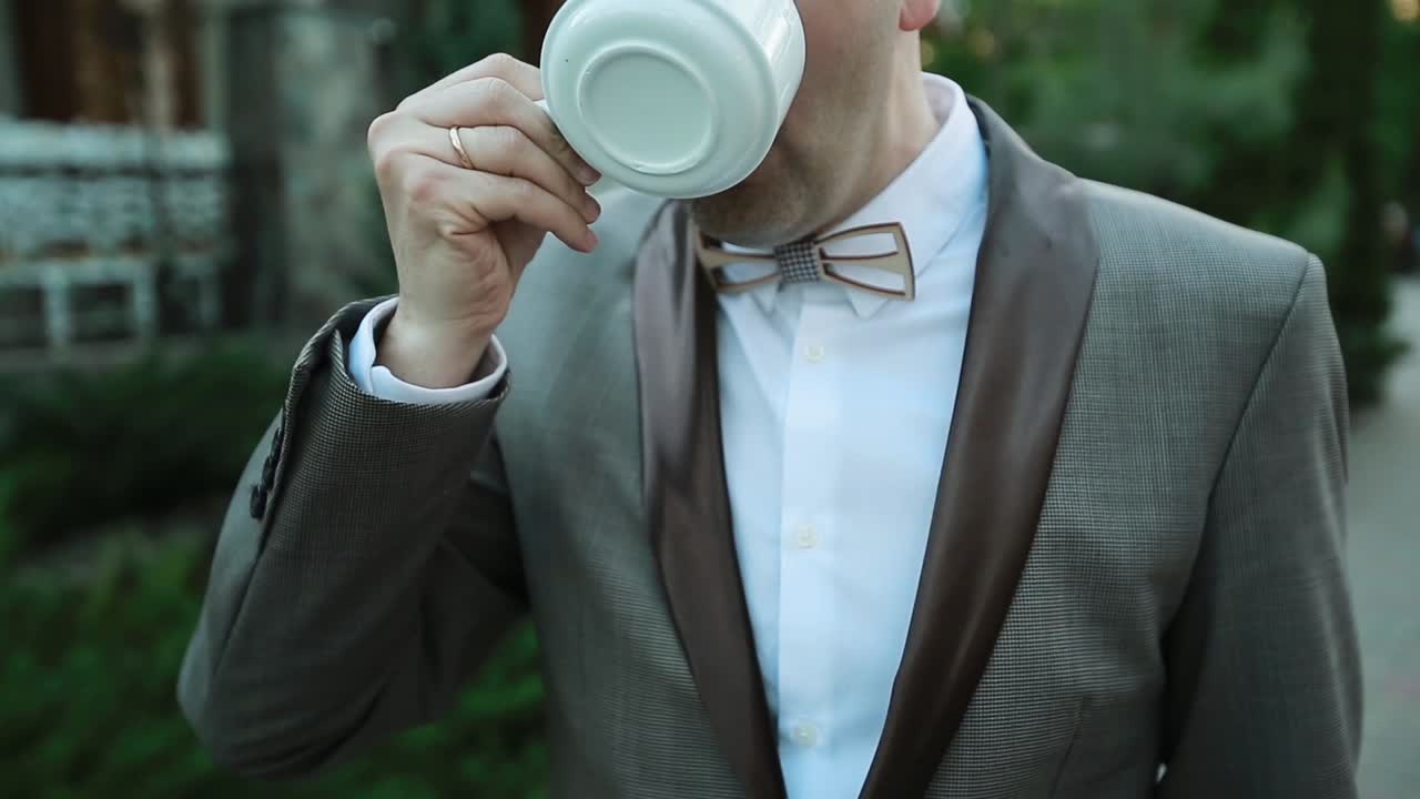 Young Man Drinks Coffee Outdoor. Young man drinks coffee on the street