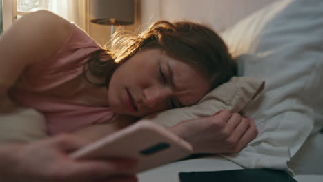 annoyed girl turning alarm clock off closeup. upset sleepy woman waking up early