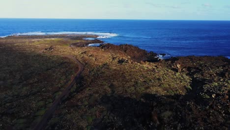 blue ocean waves hitting rocky coastline of lanzarote island, aerial view